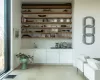 Bar with white cabinetry, sink, and light wood-type flooring