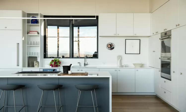 Kitchen with white cabinets, a breakfast bar, and sink