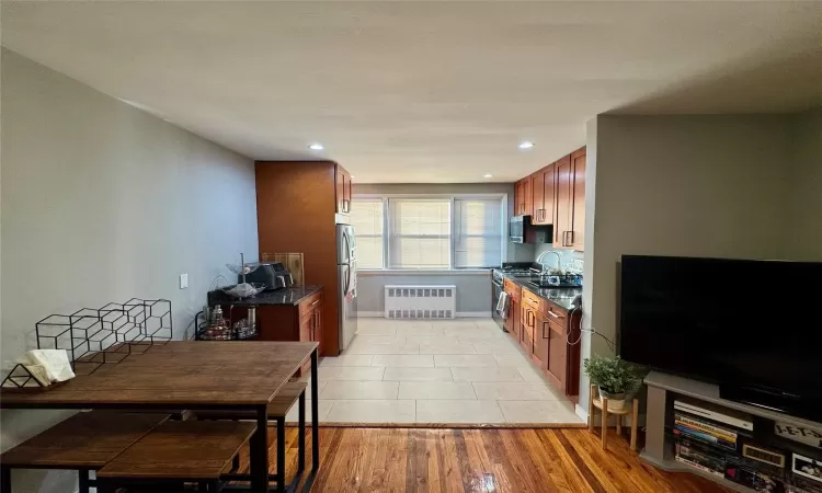 Kitchen featuring light hardwood / wood-style floors, stainless steel appliances, and radiator