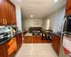 Kitchen with stainless steel fridge, dark stone countertops, and light tile patterned flooring