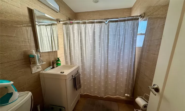 Bathroom with washer / clothes dryer, toilet, and sink