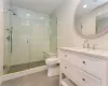 Bathroom with an enclosed shower, vanity, and toilet