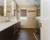 Bathroom featuring tile patterned floors, vanity, toilet, and an enclosed shower