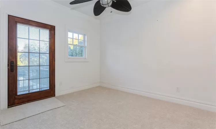 Spare room with ceiling fan, light colored carpet, and ornamental molding