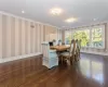 Dining space featuring ornamental molding and dark wood-type flooring