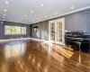 Spare room featuring dark wood-type flooring, crown molding, and french doors