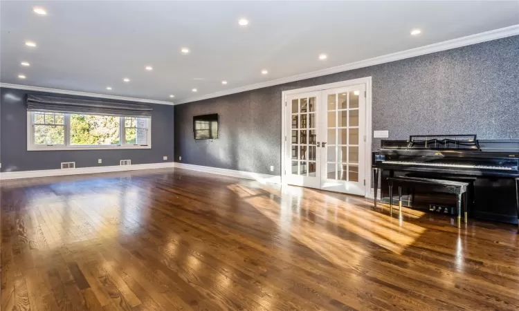 Spare room featuring dark wood-type flooring, crown molding, and french doors