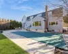 Rear view of property featuring a patio and a covered pool