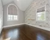 Unfurnished room with dark wood-type flooring and lofted ceiling