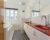 Bathroom featuring a healthy amount of sunlight, tile patterned floors, lofted ceiling, and a tub