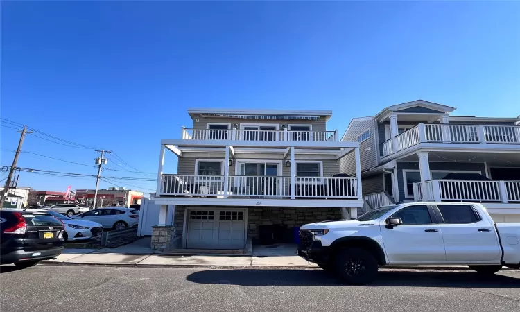 View of front of property featuring a balcony and a garage