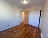 Bedroom 2 with baseboard heating, dark hardwood / wood-style flooring, crown molding, and a closet