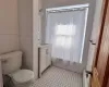 Full bathroom featuring shower / bath combination with curtain, vanity, toilet, and radiator