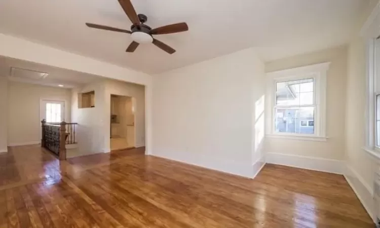 Unfurnished room with a wealth of natural light, ceiling fan, and wood-type flooring