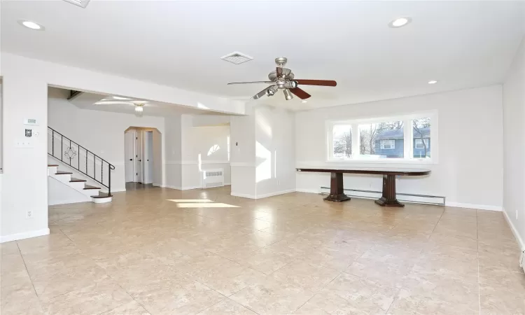 Unfurnished living room featuring ceiling fan