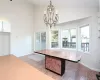 Dining room with tile patterned flooring, high vaulted ceiling, and an inviting chandelier