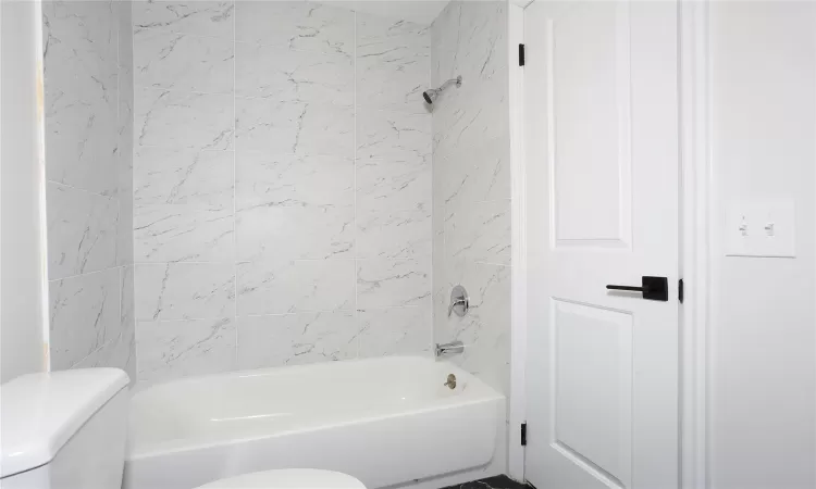 Bathroom featuring toilet and tiled shower / bath