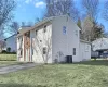 View of side of property with cooling unit and a lawn