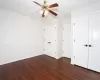 Unfurnished bedroom featuring dark hardwood / wood-style floors and ceiling fan