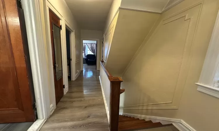 Hallway with hardwood / wood-style floors