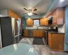 Kitchen with tasteful backsplash, stainless steel appliances, ceiling fan, sink, and light hardwood / wood-style floors