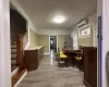 Dining area with a wall unit AC and light hardwood / wood-style flooring