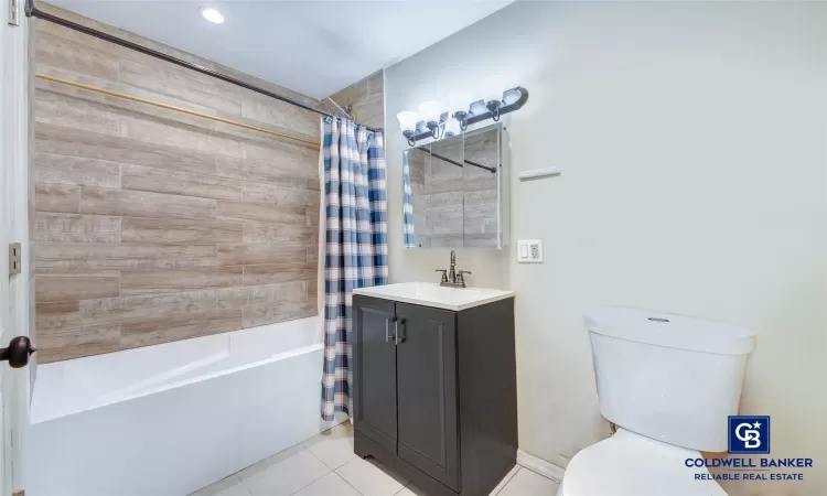 Full bathroom featuring vanity, tile patterned flooring, shower / bathtub combination with curtain, and toilet