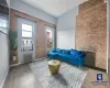 Sitting room featuring brick wall, wood-type flooring, radiator, and cooling unit