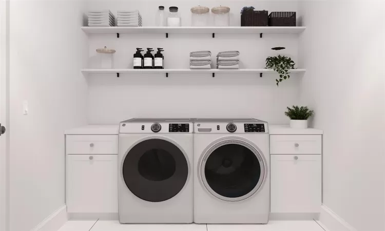 Laundry area with washing machine and clothes dryer, light tile patterned flooring, and cabinets