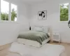 Bedroom featuring hardwood / wood-style flooring and multiple windows