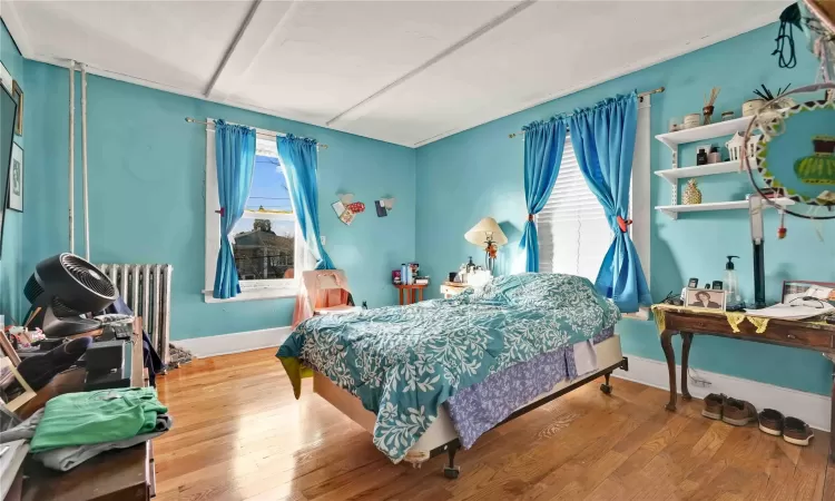 Bedroom featuring hardwood / wood-style flooring and radiator heating unit