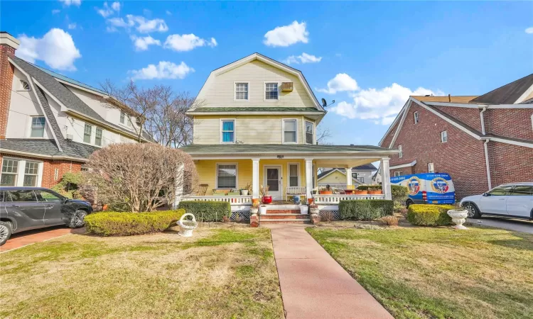 View of front facade with a porch and a front lawn