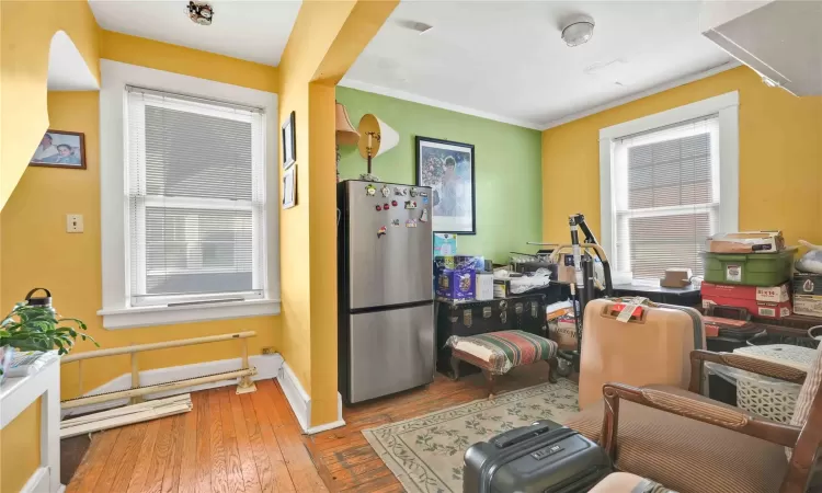 Kitchen featuring stainless steel fridge, hardwood / wood-style floors, crown molding, and plenty of natural light