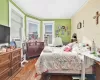 Bedroom with radiator heating unit, crown molding, and dark wood-type flooring