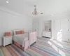 Carpeted bedroom with a closet, crown molding, and a notable chandelier