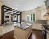 Kitchen featuring a center island with sink, sink, beamed ceiling, and cream cabinetry