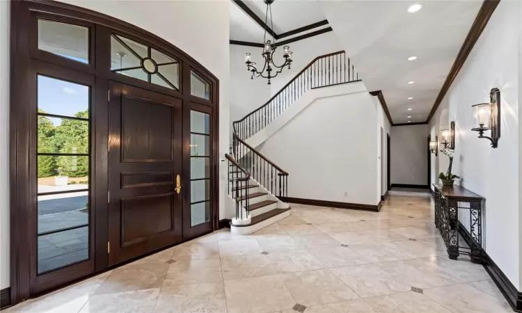 Foyer featuring crown molding and a chandelier