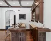 Bar with beam ceiling, dark wood-type flooring, coffered ceiling, and sink