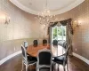 Dining space featuring dark parquet flooring, crown molding, and an inviting chandelier