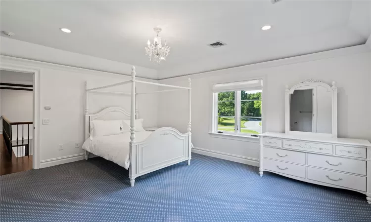 Unfurnished bedroom with dark colored carpet and an inviting chandelier