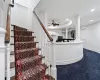 Stairs featuring ceiling fan and a raised ceiling