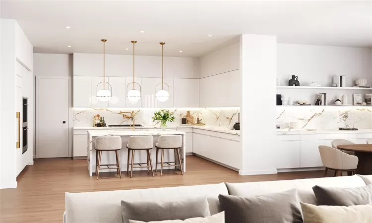 Kitchen featuring white cabinets, tasteful backsplash, hanging light fixtures, and a breakfast bar area