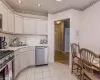 Kitchen featuring light tile patterned flooring, sink, and appliances with stainless steel finishes