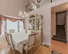 Dining area with a chandelier, a high ceiling, and light wood-type flooring