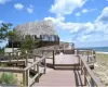 Dock area featuring a deck with water view and a beach view