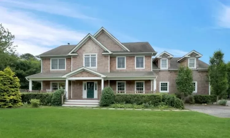 View of front facade with covered porch and a front lawn