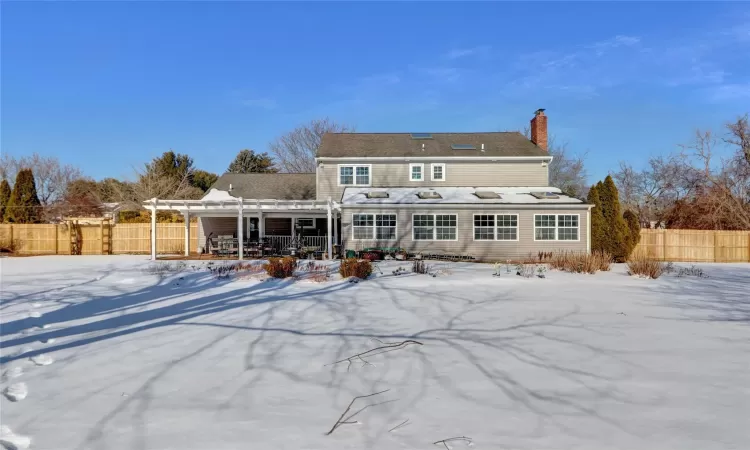 Snow covered house with a pergola