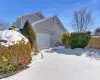 View of snowy exterior featuring a garage