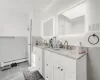 Bathroom with a baseboard radiator, vanity, and tile patterned flooring