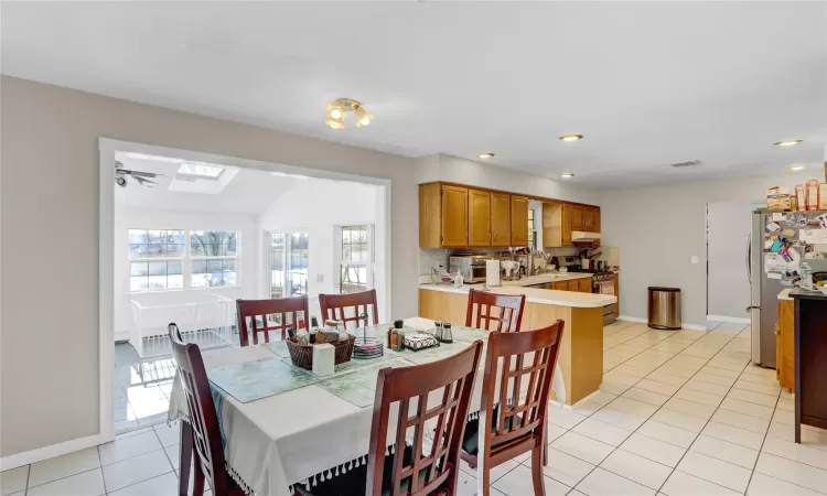 Dining room with light tile patterned floors, and a skylight